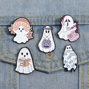 Set of five cute white enamel ghost pins featuring Halloween motifs on denim fabric