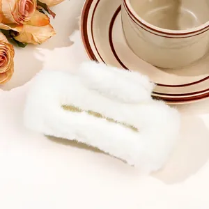 Detail of white plush hair claw clip featuring soft faux fur texture and rectangle design