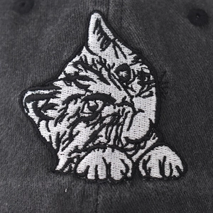 Close-up of cat face embroidery on dark gray washed cotton baseball cap texture