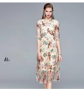 Close-up of intricate floral embroidery on beige tulle midi dress with half sleeves