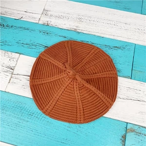 Detailed top view showing the knitted texture and orange core-spun yarn of the beret hat