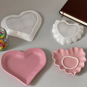 Macro view of heart-shaped lace resin molds and finished pink trays with accessories