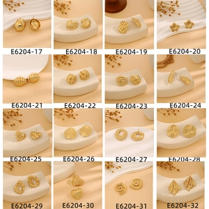Macro shot of assorted golden earrings with textured metal and unique pleated designs