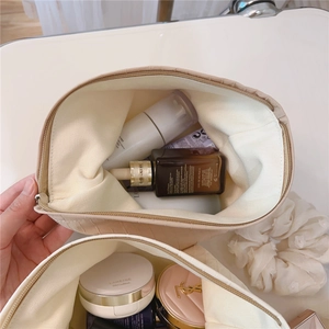 Detailed view of beige embossed makeup bag interior showing large storage capacity