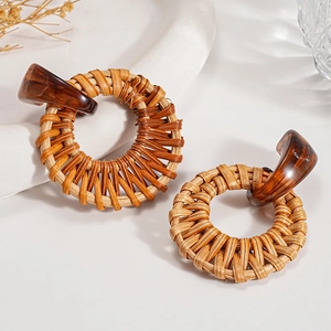 Bohemian rattan weave geometric round earrings with amber resin accents on white tray