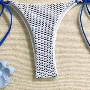 Close-up of blue bikini bottom with white crochet mesh overlay and side ties detail