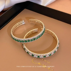 Elegant gold open bangle with emerald and zircon square stones in a double-row geometric design
