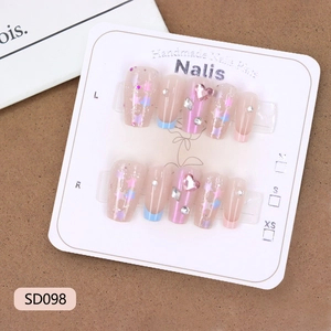 Handmade press-on nails with blue French tips, stars, and pink heart charms