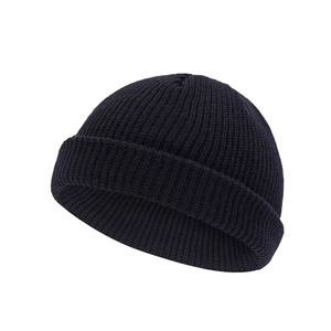 Close-up of black knit beanie skull cap showing fine texture and elastic ribbing detail