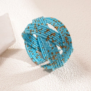 Detailed close-up of bohemian multi-layer blue and gold beaded wide cuff bracelet