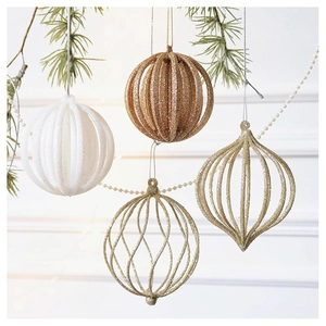 Detail of glitter champagne hollow ornaments hanging on a green Christmas tree branch