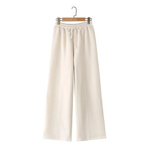 Detail of off-white knitted wide-leg pants with elastic drawstring waistband on a hanger