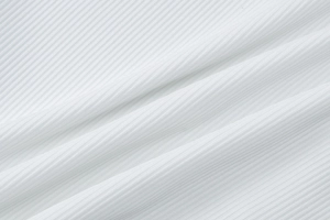 Macro texture detail of white ribbed knit fabric showing fine vertical lines and elasticity