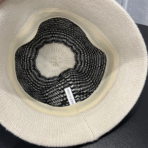Detail of knitted bucket hat interior showing black and white striped wool lining