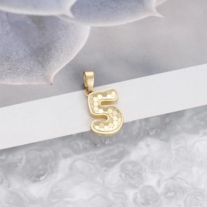 Macro shot of gold number 5 pendant with honeycomb texture and smooth bail clasp