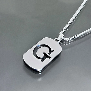 Vue détaillée du collier en acier inoxydable argenté avec pendentif lettre G ajouré
