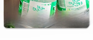 Close-up of a kitchen adhesive bottle with a green label on a dark wood surface