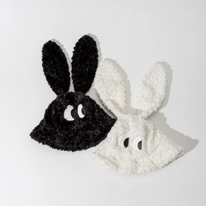Détail de chapeaux bobs en peluche avec de longues oreilles et des yeux en noir et blanc