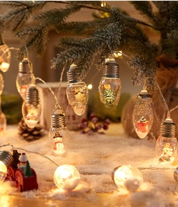 Close-up of LED Christmas bulbs with miniature Santa and snow figures inside for decoration