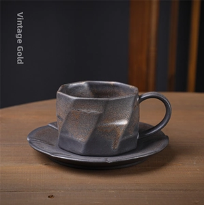 Macro shot of vintage gilded ceramic coffee cup and saucer with dark matte finish