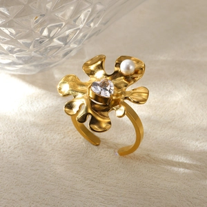 Detail of gold flower ring with heart zirconia, pearl accent and open band design