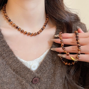 Macro shot of tiger eye beaded necklace and bracelet set with silky luster and metal beads