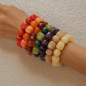 Close-up of colorful acrylic beaded bracelets with irregular shapes worn on the wrist