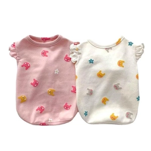 Detail of pink and beige cotton dog vests with cute bunny patterns and ruffle sleeves