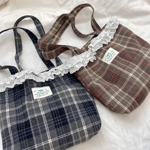 Detail of vintage plaid tote bags with lace trim and happy embroidered patches