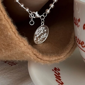 Vintage 925 sterling silver beaded chain bracelet with embossed coin pendant in lifestyle set