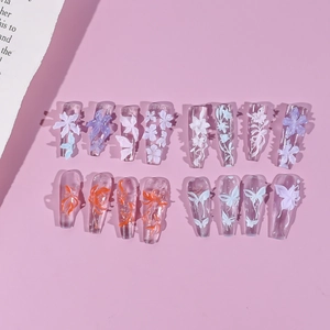 Detail of 3D embossed floral nail art tips with purple flowers and white butterflies