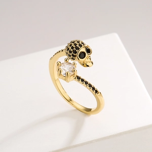 Punk style skull ring in gold plating with black and white zircon stones in side view