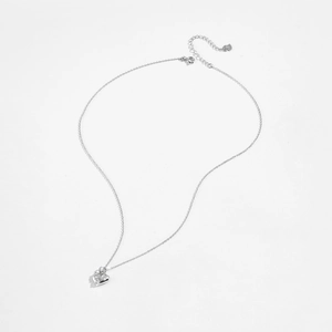Macro shot of silver S925 heart pendant with clear cubic zirconia on delicate cross chain