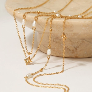 Multi-layer gold stainless steel necklace with natural pearls and star pendant on marble