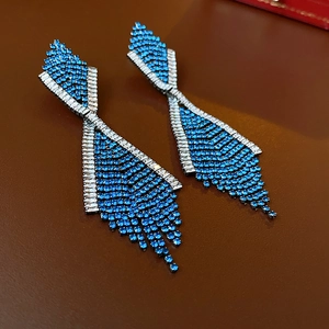 Detailansicht silberner geometrischer Fransencohrringe mit blauen Glitzersteinen
