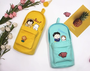 Close-up of cute backpack-style canvas pencil cases in yellow and mint green