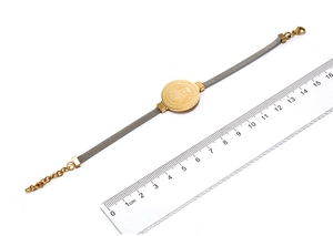 Golden Saint Benedict medal bracelet with silver watch strap band being measured at 19cm