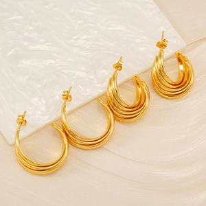 Detailed view of 18K gold-plated C-shaped layered earrings with polished vertical texture