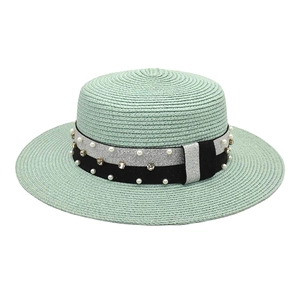 Detailed shot of mint green boater straw hat featuring a pearl and rhinestone band