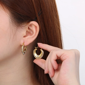Gros plan de boucles d'oreilles cœur et lune dorées ajourées ornées de strass blancs