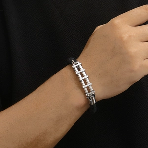 Dettaglio del bracciale intrecciato da uomo con metallo argento e zirconi incastonati