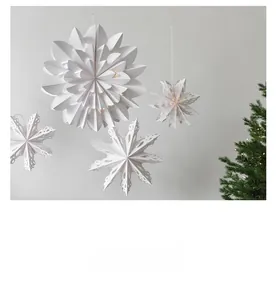 Macro shot of white folded paper snowflakes and stars with internal warm LED lights