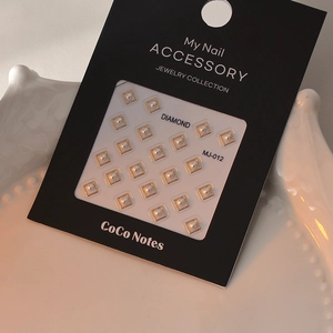 Macro shot of 20pcs gold square pearl nail art charms on a CoCo Notes display card