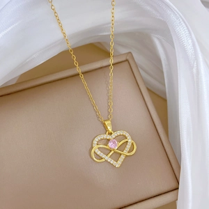 Detail of gold heart pendant necklace with pink stone and clear crystals on silk
