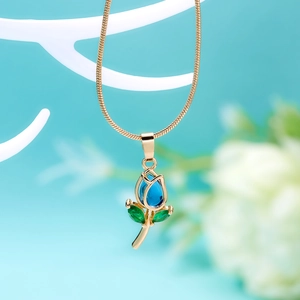 Macro detail of tulip pendant necklace with blue gemstone bud and green crystal leaves
