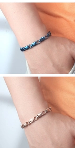 Dettaglio delle maglie a doppio cuore su bracciali per magnetoterapia blu e oro rosa