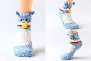 Detail view of cartoon cat socks with coral fleece material and decorative yellow bells