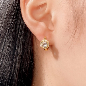 Macro shot of gold-plated hoop earring with micro-pave cubic zirconia on earlobe