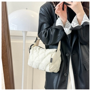 Vue miroir d'un petit sac à bandoulière matelassé blanc porté par un mannequin