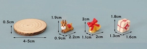 Detailed size view of miniature wood slice, reindeer, bell, and gift box decorations